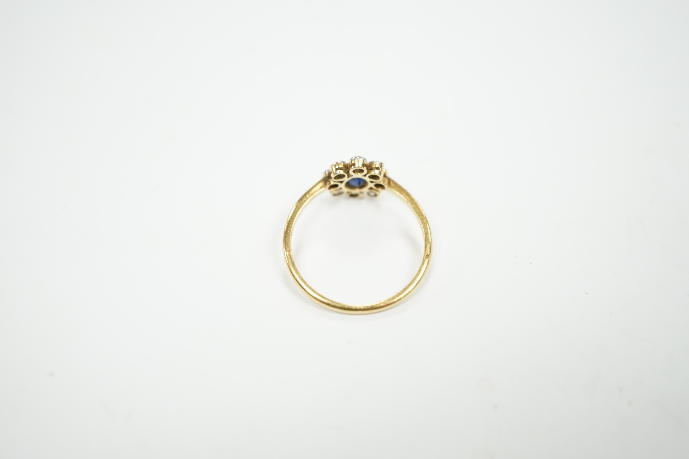 An 18ct, sapphire and diamond cluster set oval ring, size M, gross weight 2 grams.